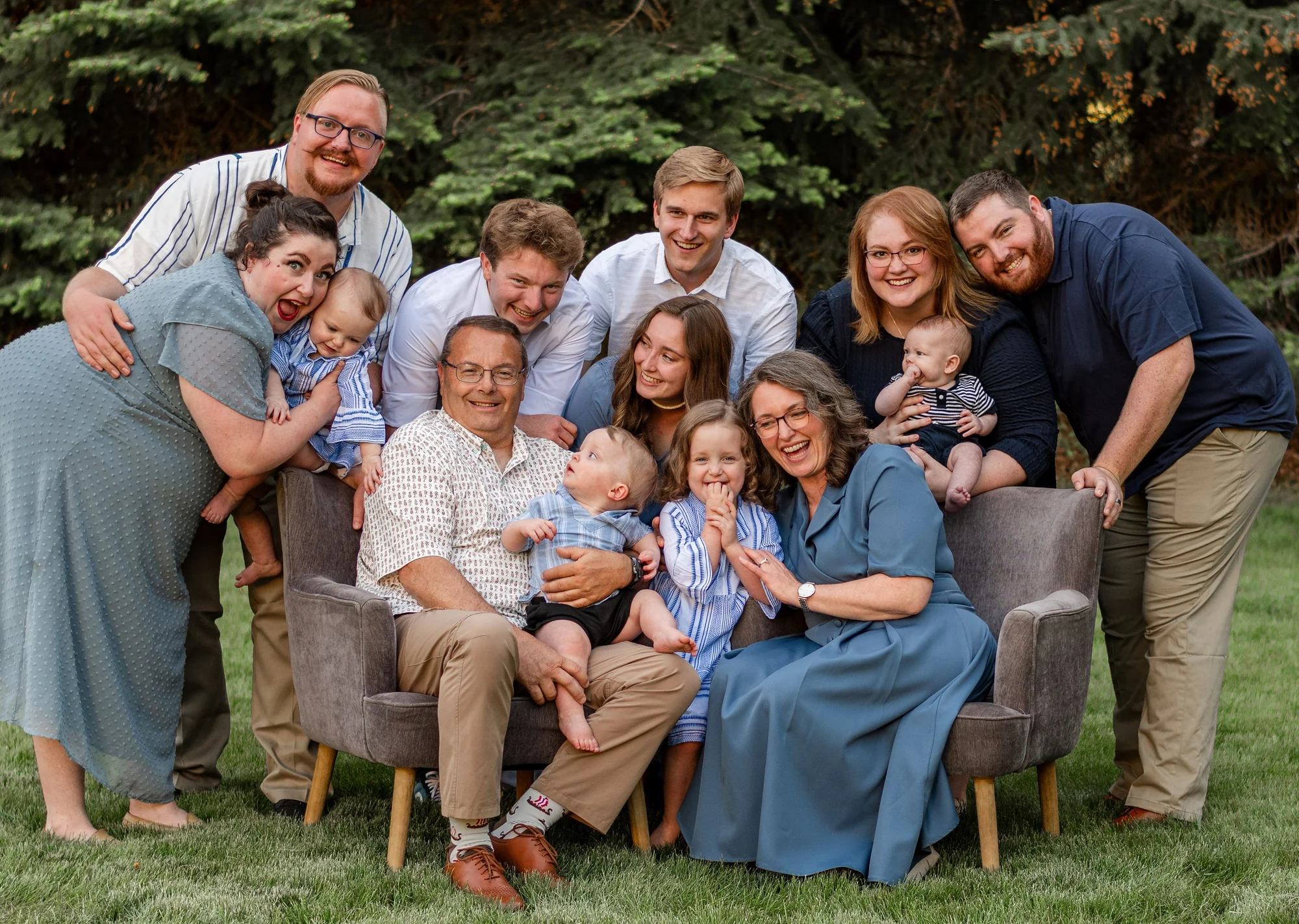 Multigenerational family smiling together outdoors on lawn